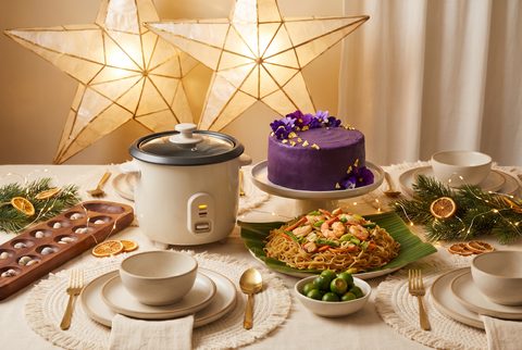 Noche Buena table under a glowing capiz star parol with a rice cooker, purple ube cake, pancit and calamansi