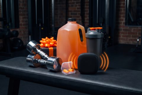 Gym bench with a gallon water jug, dumbbells, a shaker bottle and a wrapped gift
