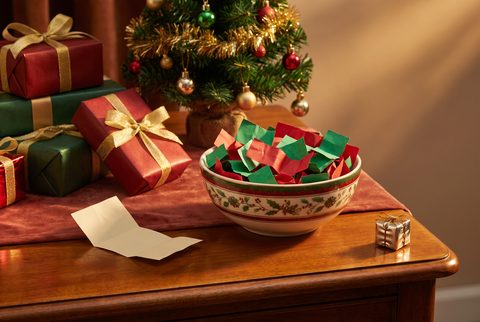Holiday table with wrapped gifts, a bowl of candy, a folded name card and a small Christmas tree